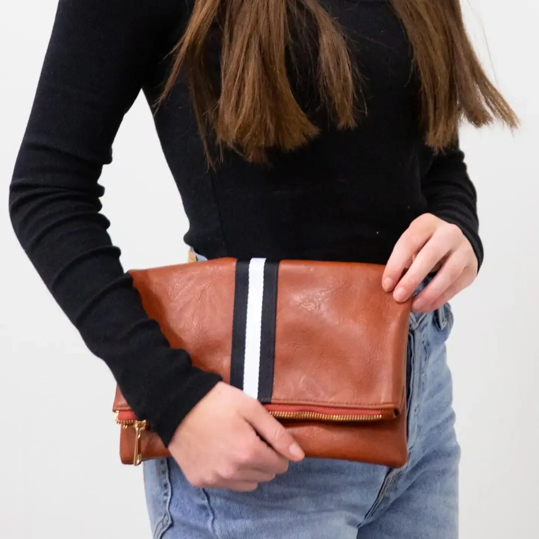 A woman holding onto a brown leather purse